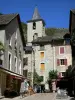 Sainte-Enimie - Clocher de l'église Notre-Dame-du-Gourg, façades de maisons, boutique et terrasse de café