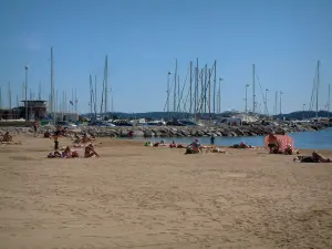 Sainte-Maxime - Sandy strand van het resort met vakantiegangers, Middellandse Zee en zeilen (boten) van de jachthaven
