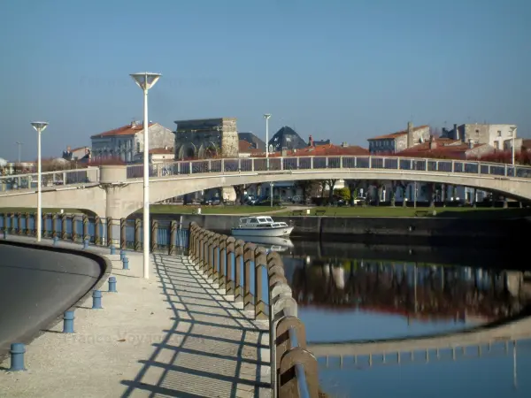 Saintes - Quai avec des lampadaires, pont enjambant le fleuve (la Charente), bateau, arc de Germanicus et maisons de la ville