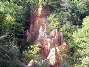 Saints valley - Fairy chimneys (column-like rock formations with caps) of ocher colour surrounded by trees; in Boudes