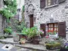 Salers - Entrée d'une maison en pierre décorée de fleurs