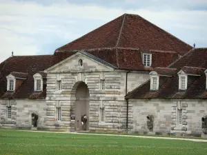 Saline royale d'Arc-et-Senans - Bâtiment de l'ancienne saline royale et pelouse parsemée de fleurs