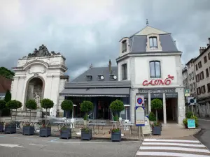 Salins-les-Bains - Kurstadt: Häuserfassaden, Brunnen, Restaurant-Terrasse, Sträucher in Blumentöpfen