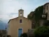 Sant'Antonino - Iglesia de color (fachada de color amarillo y la puerta azul) y casas de la aldea (en Balagne)