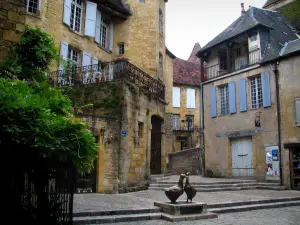 Sarlat-la-Canéda - Platz Marché-aux-Oies mit seiner Skulptur, Patrizierhaus Magnanat (Patrizierhaus Gisson) und sein sechseckiger Turm links, im Périgord