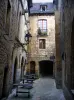 Sarlat-la-Canéda - Maisons en pierre, lampadaires et alignement de tables