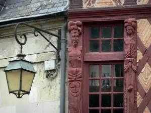Saumur - Lamppost and wooden characters carved on the facade of an period house
