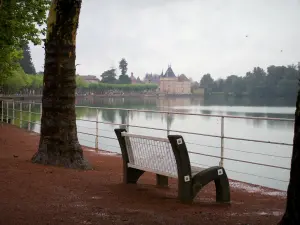 Schloß von La Clayette - Sitzbank mit Blick auf den See, das Schloß und die Bäume am Wasserufer