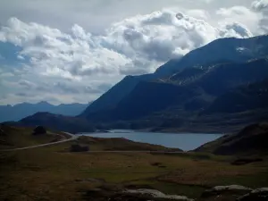 See Mont-Cenis - Bergwiesen, See (Wasserreservoir), Berge (Massiv Mont-Cenis) und Wolken im Himmel, in der Haute-Maurienne (peripherische Zone des Nationalparks Vanoise)