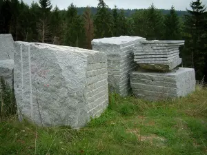 Sidobre - Blocks and sliced granite rock, forest in background in the Upper Languedoc Regional Nature Park