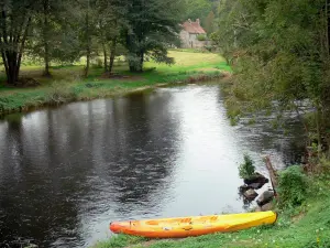 Sioule gorges - Canoe along the river Sioule, trees and house in the background