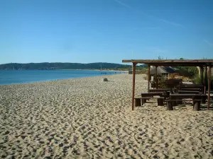 Spiaggia di Pampelonne - Baia di Pampelonne a Ramatuelle: spiaggia di sabbia, bar sulla spiaggia, il mare Mediterraneo e la foresta in background