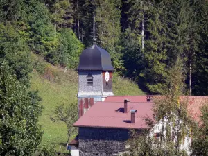 Station des Monts Jura - Station de sports d'hiver (ski) et d'été : village de Mijoux : clocher de l'église, maison et arbres ; dans le Parc Naturel Régional du Haut-Jura (massif du Jura)