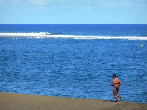 Strände der Réunion - Rennen am schwarzen Sandstrand von Etang-Salé-les-Bains, am Ufer des Indischen Ozeans