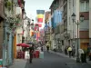 Strassburg - Grand'Rue mit aufgehängten Fahnen, Häuser dekoriert mit Blumen, Kaffeeterrasse und Boutiquen