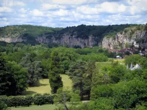 Tal der Dordogne - Kirche und Häuser des Dorfes Gluges, Felsen, Bäume und Wolken im Himmel, im Quercy