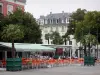 Tarbes - Place de Verdun : terrasse de café, palmiers en pots, arbres et immeubles de la ville