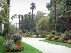 Tarbes - Jardin Massey (parc à l'anglaise) : allée bordée de massifs fleuris (fleurs), d'arbres et de palmiers