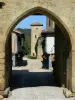 Tillac - Porche de la tour de Rabastens avec vue sur la tour de Mirande et la rue principale bordée de maisons anciennes à cornières