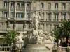 Toulon - Liberté square: the Fédération fountain, palm trees and facade of the Grand Hotel