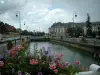 Troyes - Geländer einer Brücke dekoriert mit Blumen, mit Blick auf den Wasserlauf, die Strassenleuchten und die Gebäuden der Stadt