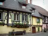 Turckheim - Farbige Fachwerkhäuser mit Blumen und einer Bank aus Holz