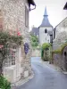 Turenne - Casa dei Canonici (o ex casa del capitolo) ornato con una arrampicata fiori rosa, e il campanile di Notre-Dame St. Pantaleon