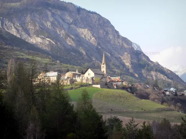 Ubaye valley - Square bell tower of the Saint-Pierre-et-Saint-Paul church and houses of the village of Saint-Paul-sur-Ubaye, meadows, trees and mountain