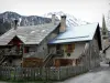 Valle del Clarée - Névache pueblo: la iglesia torre de la calle San Marcelino y las casas cubiertas de montañas de nieve en el fondo