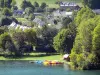 Valle del Louron - Lago Genos-Loudenvielle, pedalò colorate ormeggiate a fianco con alberi e le case che dominano l'intera