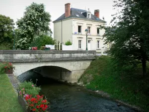 Vallée du Loir - Pont enjambant la rivière Loir, façade de maison, décorations florales et arbres au bord de l'eau ; à La Chartre-sur-le-Loir
