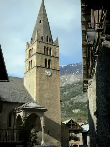 Vallouise - Bell tower and hall of the Saint-Etienne church, traditional chalets and mountain; in the Écrins National Nature Park