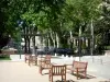 Vals-les-Bains - Strasse gesäumt von Bäumen, Sitzbänke und Stühle aus Holz vorne