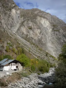 Vénosc - Oisans - Écrins mountains (town in the Écrins National Park) - Vénéon valley: house and trees along the Vénéon stream, mountain overhanging the place