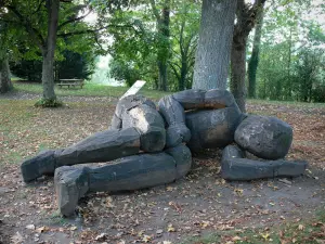 Verneuil-en-Bourbonnais - Sleeping giant (wood sculpture) at the foot of a tree; in Motte Coquet