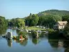 Vernon - River Seine, piles of the old medieval bridge, old half-timbered mill, boats and trees along the water