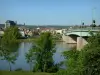 Vernon - Clemenceau bridge spanning River Seine, trees along the water, and Notre-Dame collegiate church in the background overlooking the town