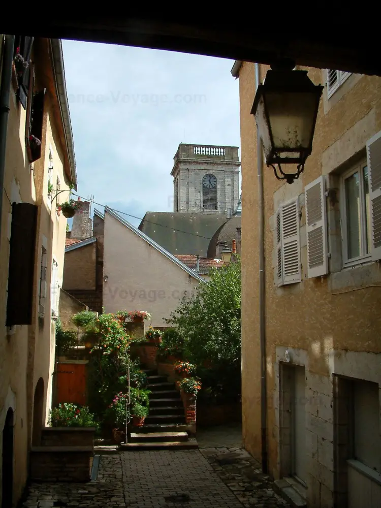 Vesoul - Lampadaire, maisons aux façades colorées, escalier d'entrée décoré de fleurs et tour de l'église Saint-Georges