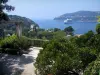 Villa Ephrussi de Rothschild - Garden of the palace with view of the natural harbour of Villefranche-sur-Mer, Mediterranean Sea with a cruise boat and the mount Boron in background