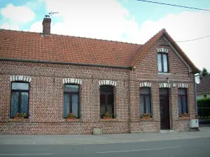 Villages du Pas-de-Calais - Route et maison en brique aux fenêtres décorées de fleurs