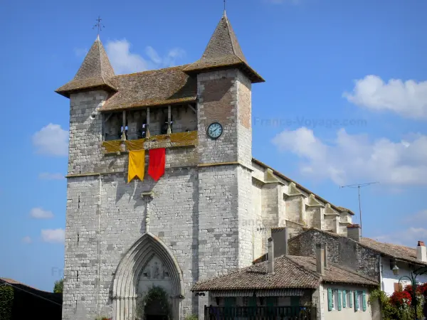 Villeréal - Medieval bastide town: fortified Notre-Dame church; clouds in blue sky