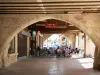 Villeréal - Bastide médiévale : terrasse de café sous les cornières de la place de la Halle