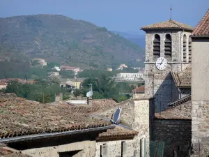 Vogüé - Kirchturm der Kirche Sainte-Marie und Häuser des Dorfes mit Blick auf die umliegende Hügellandschaft