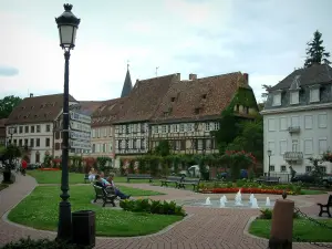 Wissembourg - Parque con lámparas, fuentes, bancos, césped y flores, casas antiguas