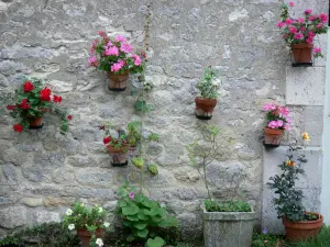 Yèvre-le-Châtel - Pots de fleurs ornant une façade en pierre