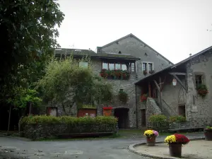 Yvoire - Square decorated with flowers in jars, houses with geranium-bedecked windows (geranium flowers)