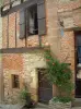 Корд-сюр-Ciel - Восхождение на розы (розы) и фасад дома в средневековом городе, смешивая кирпич, камень и дерево