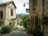 Корд-сюр-Ciel - Мощеная наклонная улица и дома украшены цветами и растениями