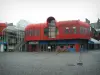 Сен-Брие - Мощеная площадь с современным зданием в красном цвете