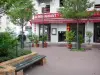アジアの近所 - アジアンレストランとベンチのある小さな広場の正面